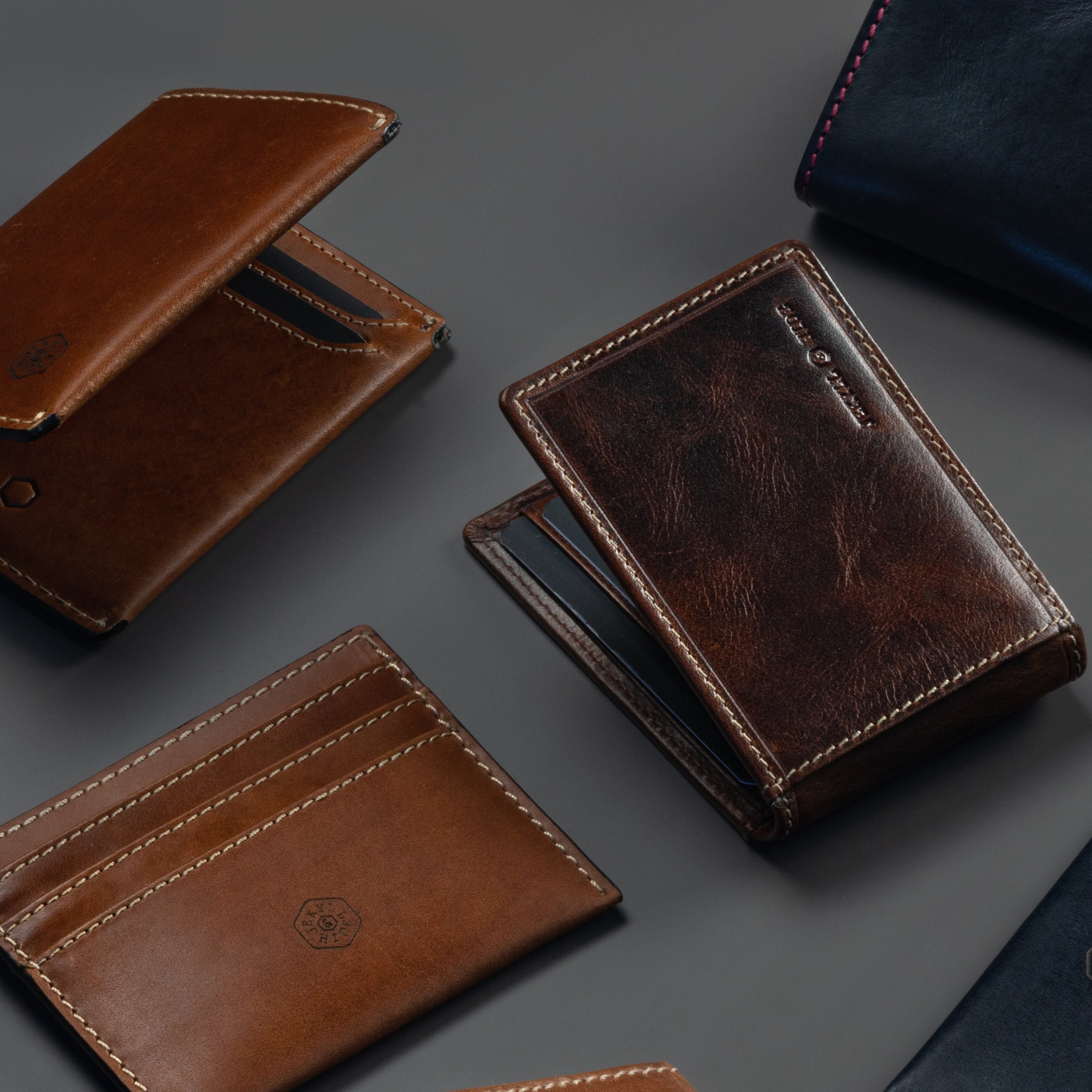 Collection of brown and blue leather wallets on a dark gray background