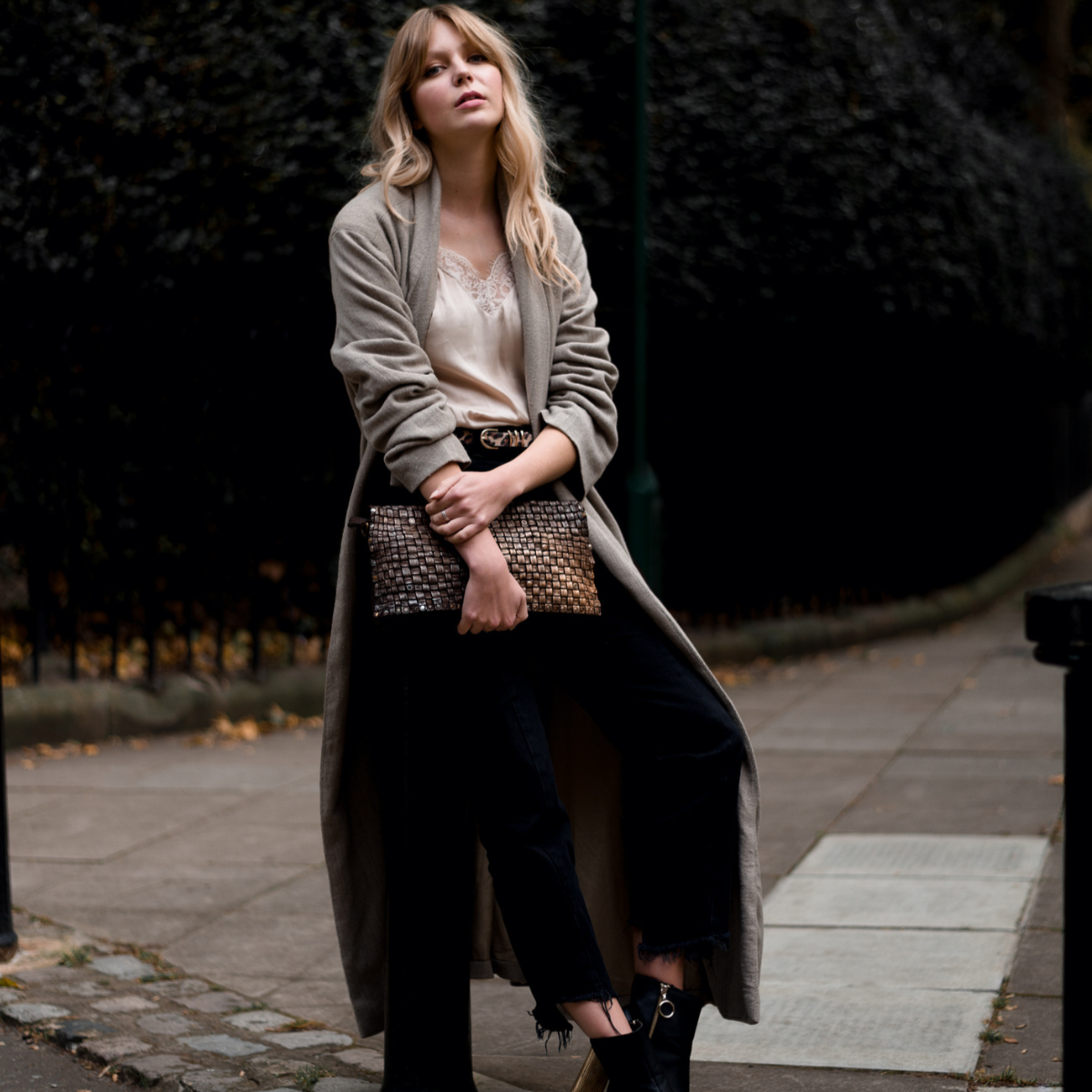 Woman walking on a street holding a patterned handbag